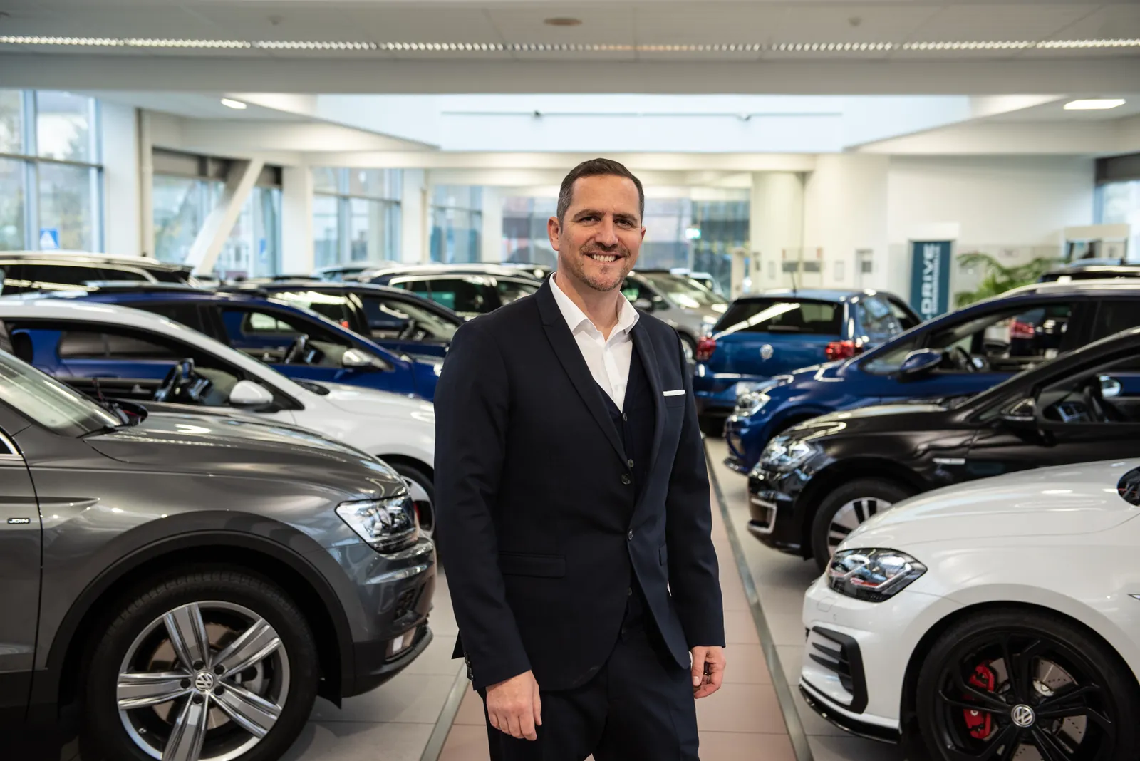Alexander Kropf im Showroom eines Glinicke-Autohauses zwischen Neuwagen